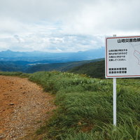 毛無峠の山地災害注意喚起看板と緑の山々・登山トレッキングの写真