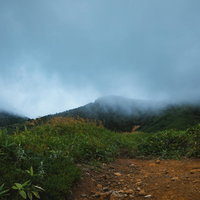 雨雲に覆われ天候悪化する毛無峠の山道と群馬の自然の写真