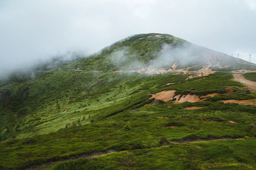 強い風が吹く毛無峠の山肌、霧と雲に覆われた悪天候時の山岳環境