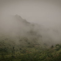 毛無峠の深い霧に包まれた古びた鉄塔と山々の風景の写真
