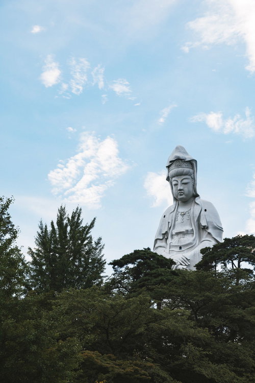 青空を背景に緑に囲まれた巨大な高崎白衣大観音