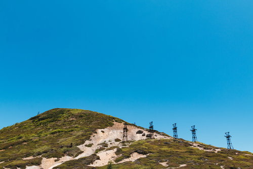 毛無峠の山の稜線に立ち並ぶ古い鉄塔群と青空の風景