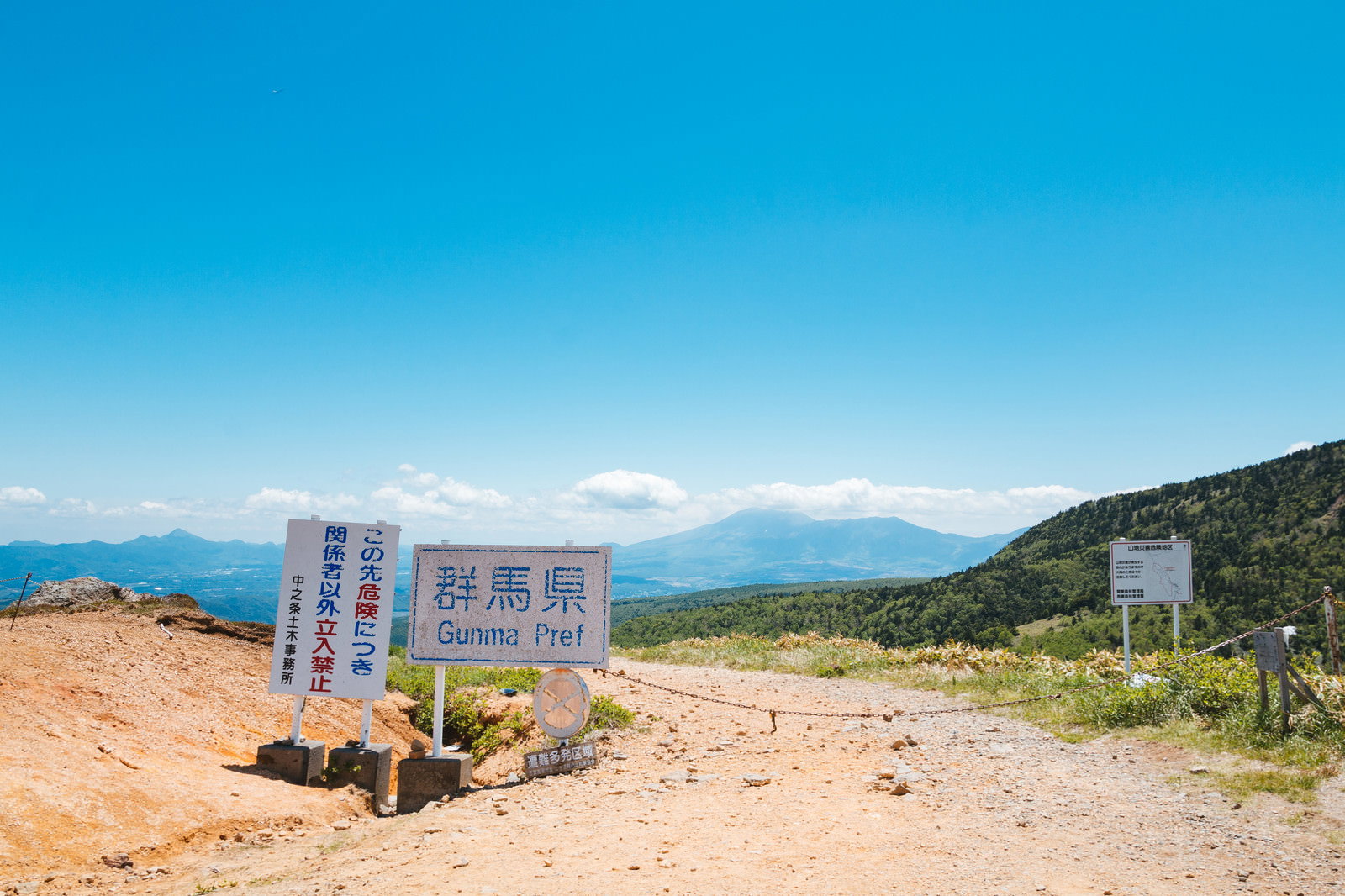 青空の下の毛無峠に設置された立入禁止の警告看板