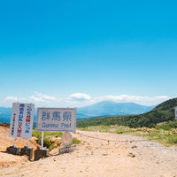 よく晴れた穏やかな毛無峠の立入禁止看板と群馬の山々の写真