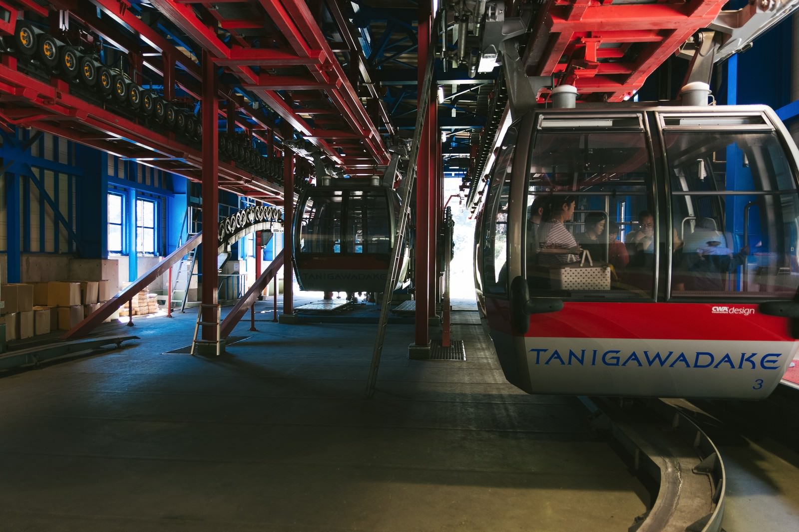 赤いロープウェイ車両が停車する駅のプラットフォーム