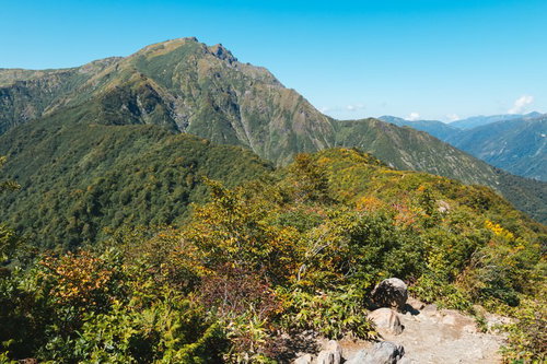 秋の谷川岳と紅葉に染まった山並み、澄んだ青空と登山道の眺望