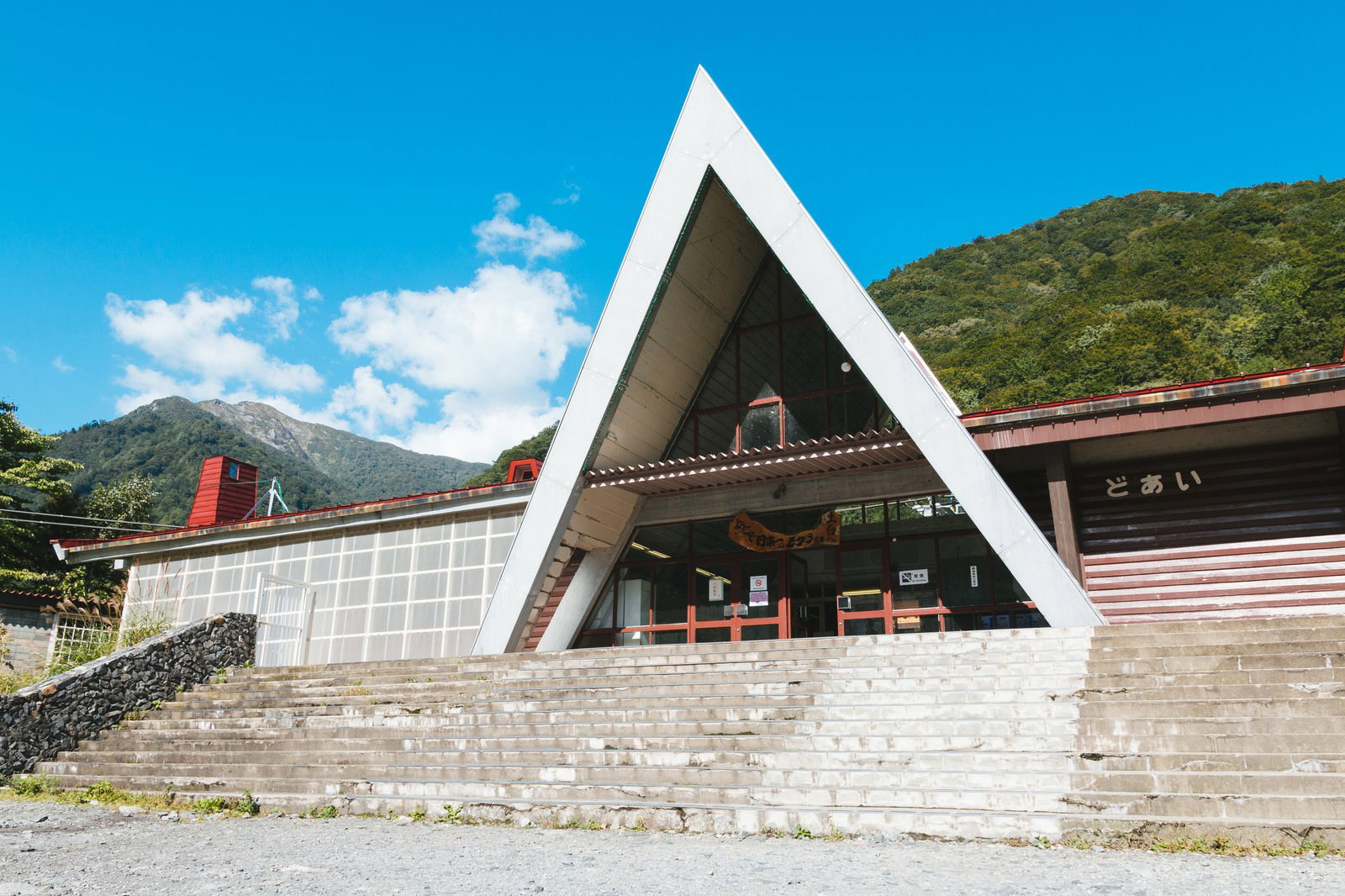 青空と山々を背景にした三角屋根の土合駅舎の建物