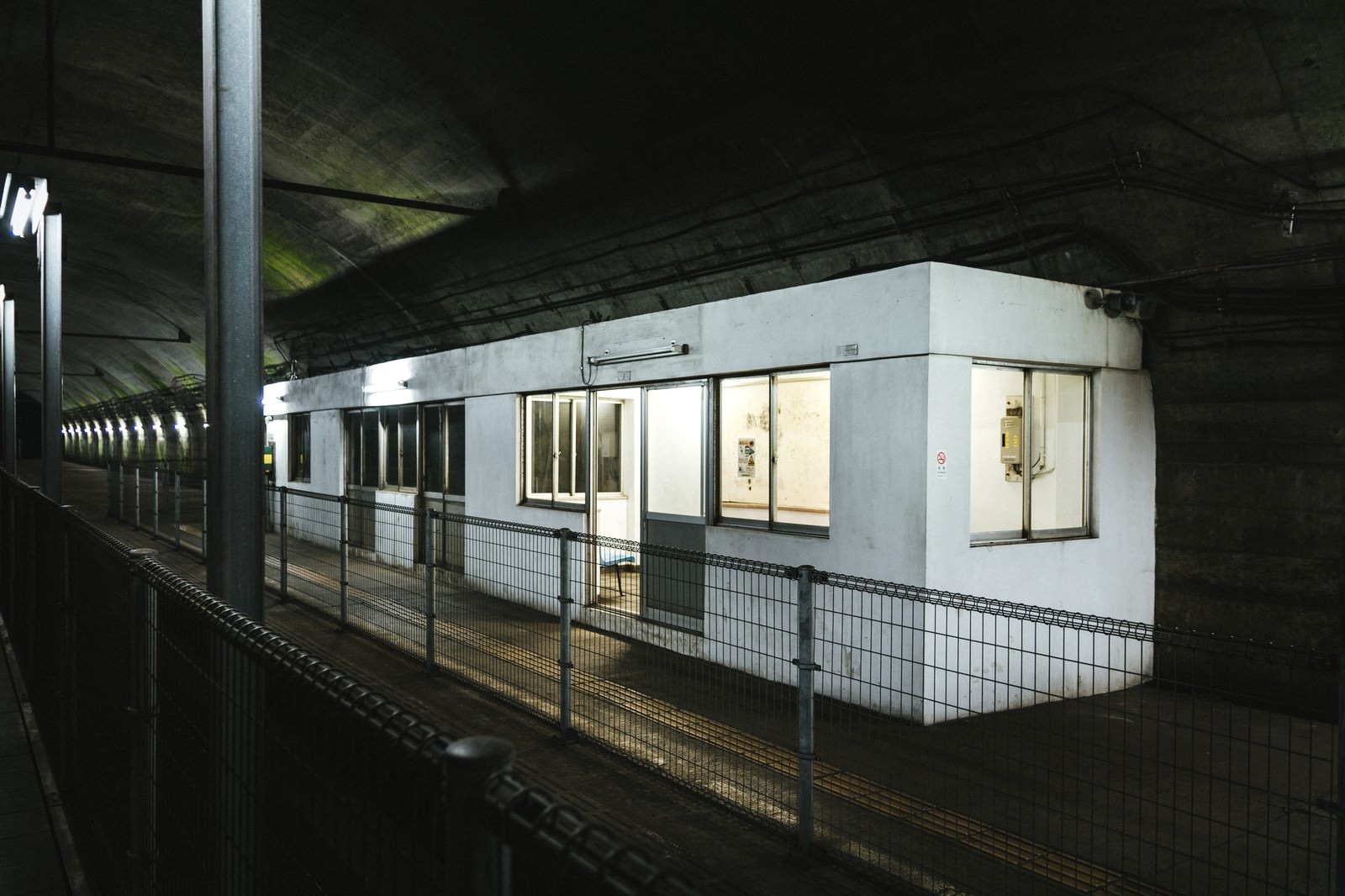 A view of the white waiting room installed on the underground platform of Dogō Station