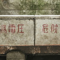 経年劣化したコンクリート壁の高電圧危険注意書きの写真