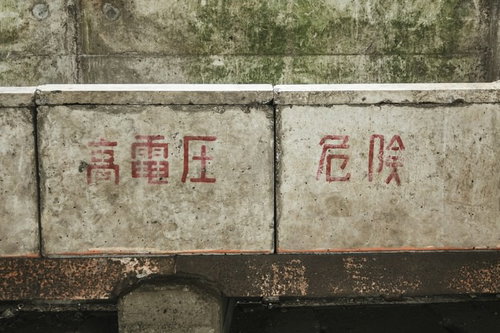 経年劣化したコンクリート壁の高電圧危険注意書き