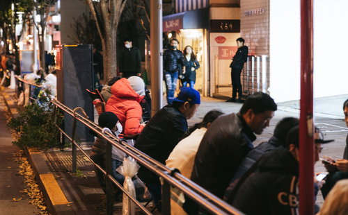 夜間の歩道に徹夜で作られた長蛇の列と大勢の群衆