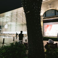 夜間のアップルストア表参道店舗前に並ぶ行列と人々の写真