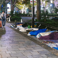 寝袋で朝をまつ徹夜行列組の写真