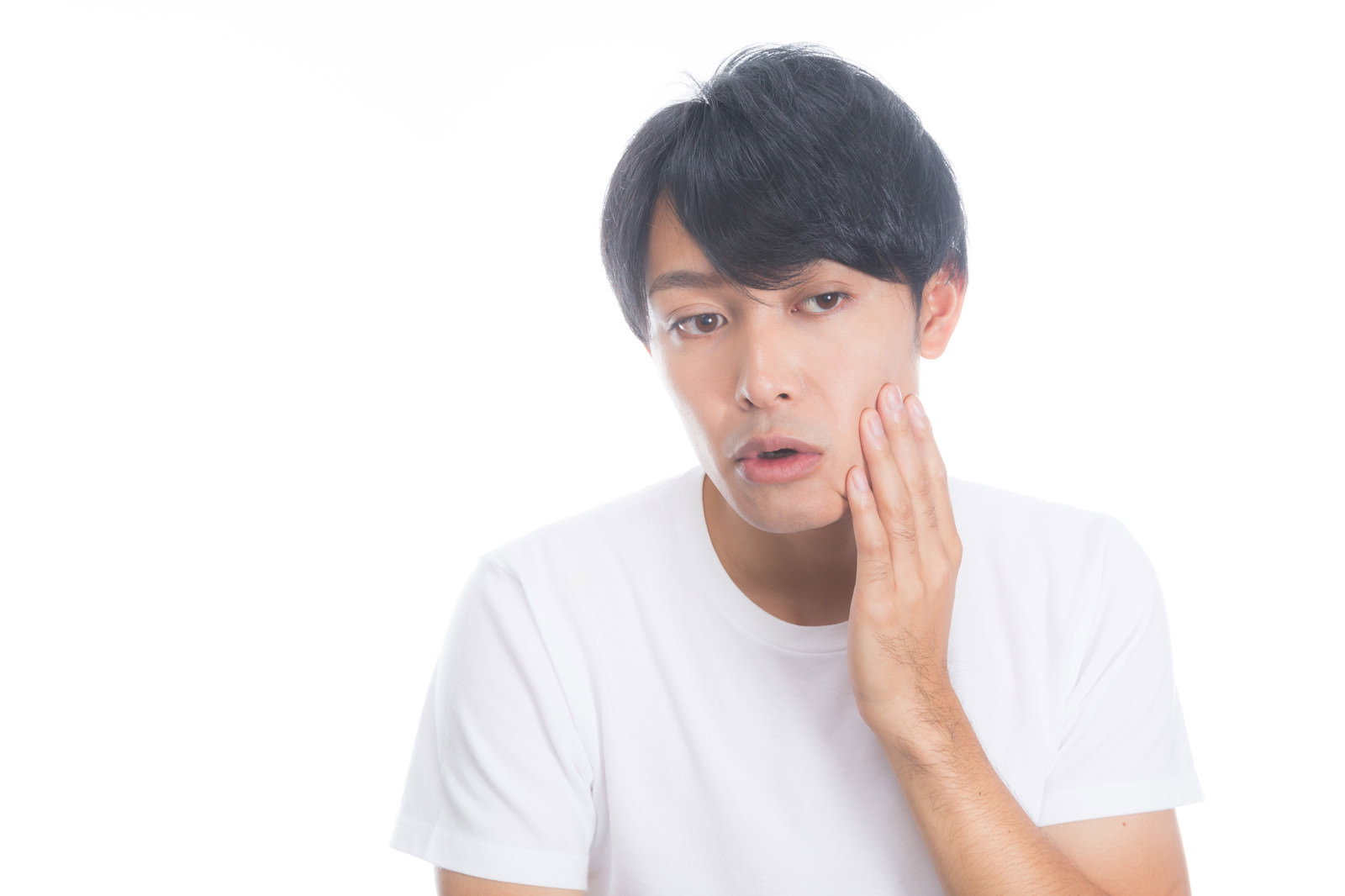 白いTシャツを着た男性が右手で頬に触れて肌荒れを気にしている様子［モデル：完伍］