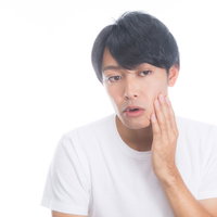 頬の肌荒れを気にする男性のスキンケアの写真