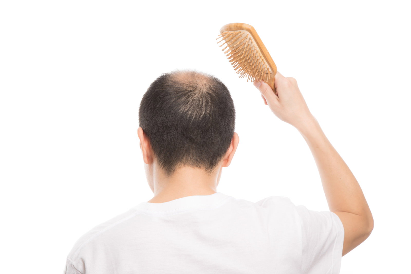 ヘアブラシで頭皮をケアする薄毛の男性の後ろ姿［モデル：サンライズ鈴木］