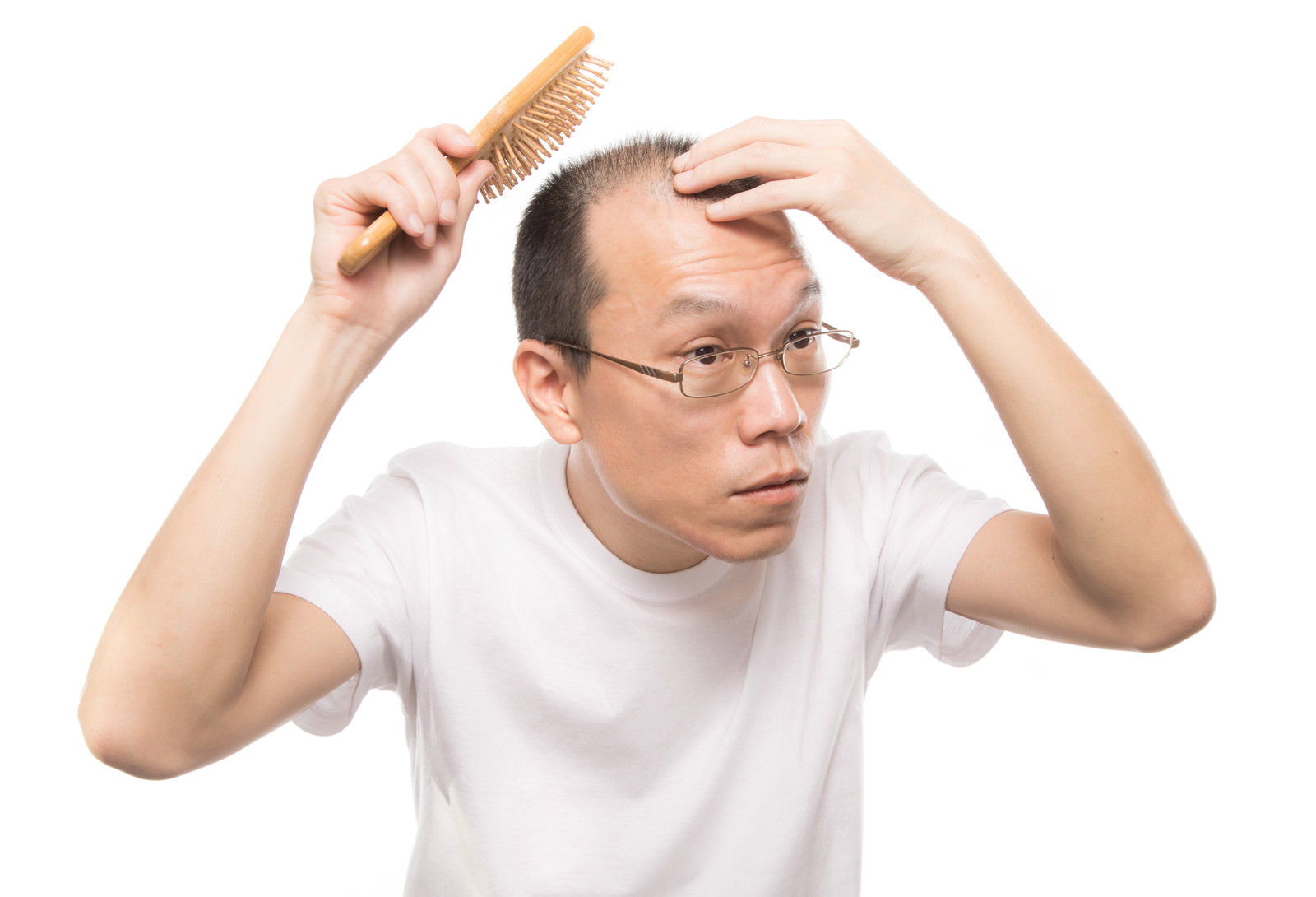 頭皮ブラシでマッサージする薄毛の男性［モデル：サンライズ鈴木］