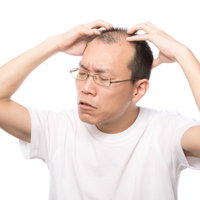 セルフ頭皮マッサージをする男性の薄毛対策の写真