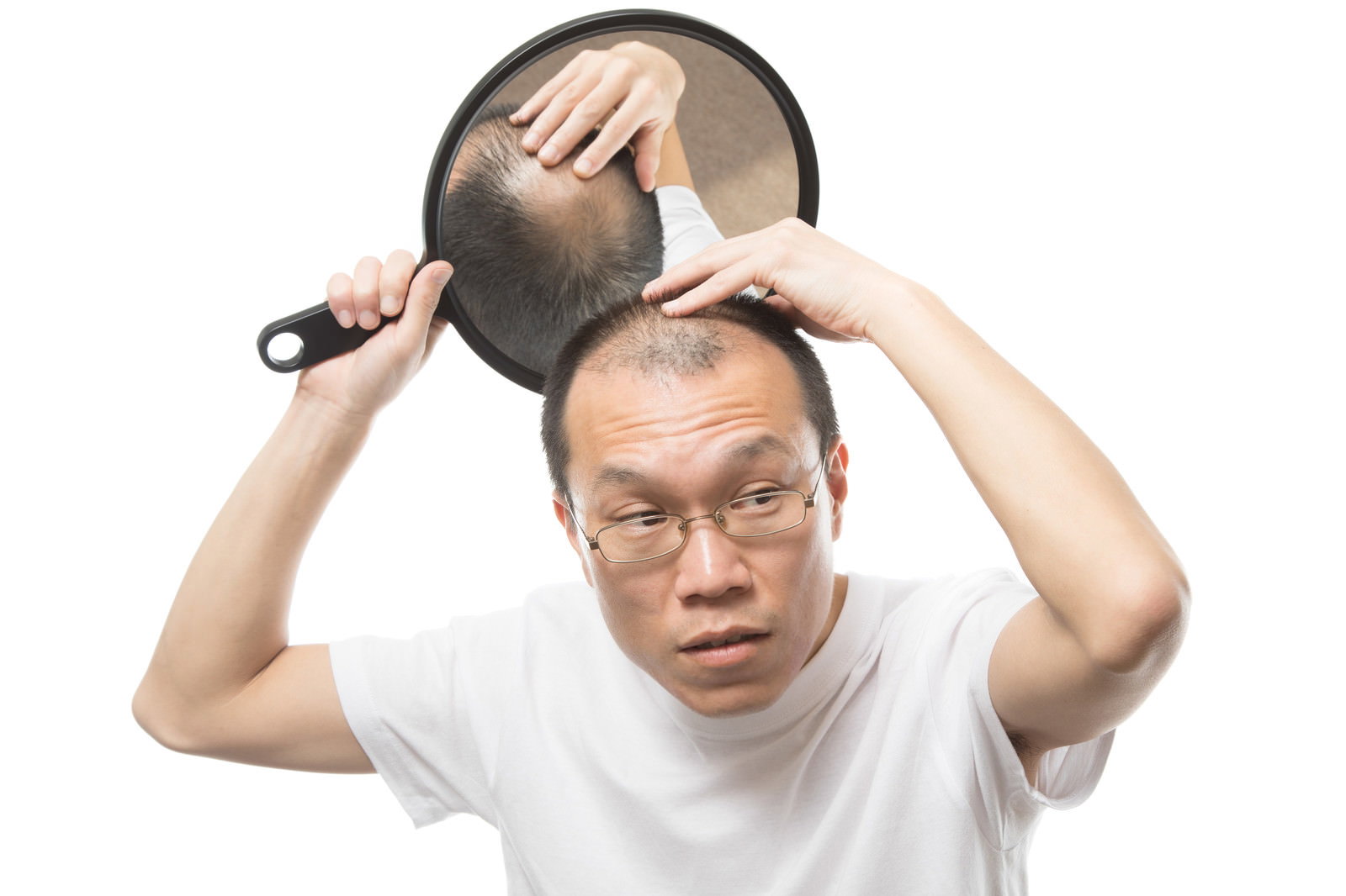 手鏡を使って頭頂部の薄毛をチェックする白いシャツの男性［モデル：サンライズ鈴木］