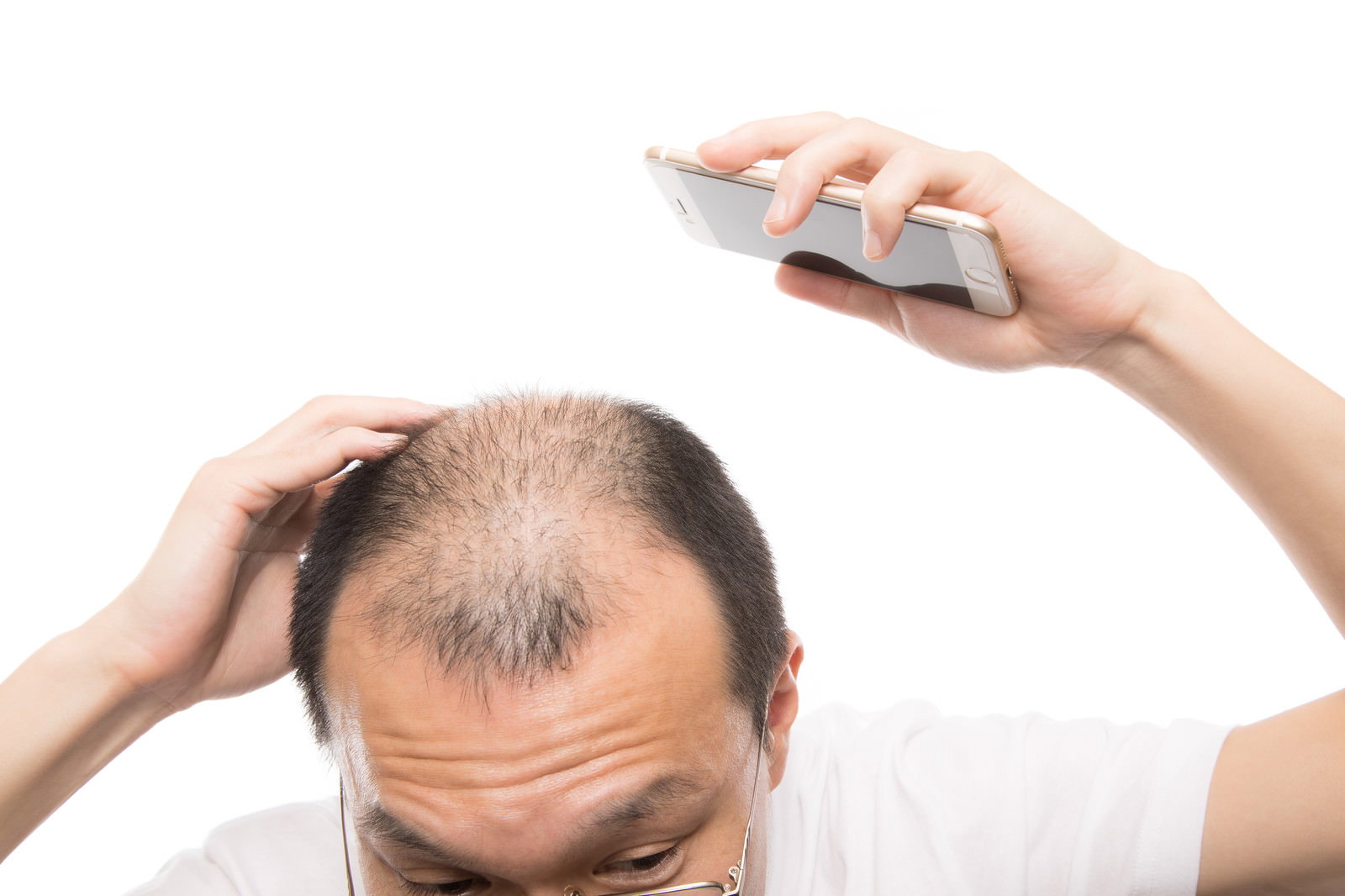 スマートフォンを使って頭頂部の薄毛具合をセルフチェックする男性［モデル：サンライズ鈴木］
