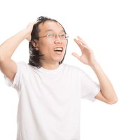 カツラがズレて両手で頭を抑えて慌てる薄毛男子の写真