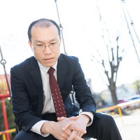 公園のブランコで項垂れてうつむく薄毛の部長の姿の写真