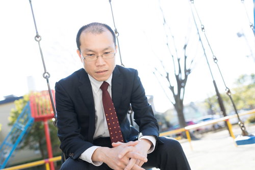 公園のブランコで項垂れてうつむく薄毛の部長の姿