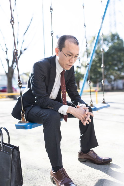 会社に戻るのが嫌だと項垂れるスーツ姿の男性