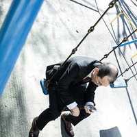 ストレスで項垂れる薄毛の会社員男性の写真