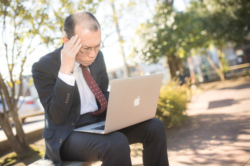 成果があがらず仕事のストレスでハゲそうなスーツ姿の営業（アラサー）