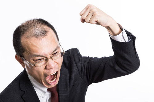 怒鳴り散らしてこぶしを振り上げるハゲリーマン