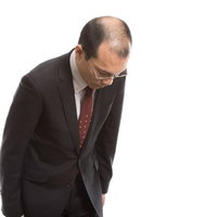 ハゲを気にしてお辞儀の角度が浅い会社員男性の写真
