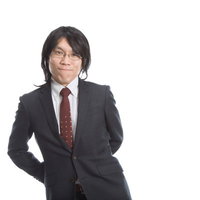 カツラをかぶり笑顔をふりまく会社員の写真