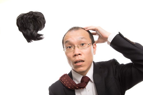 強風でカツラが飛ばされ唖然とする男性会社員