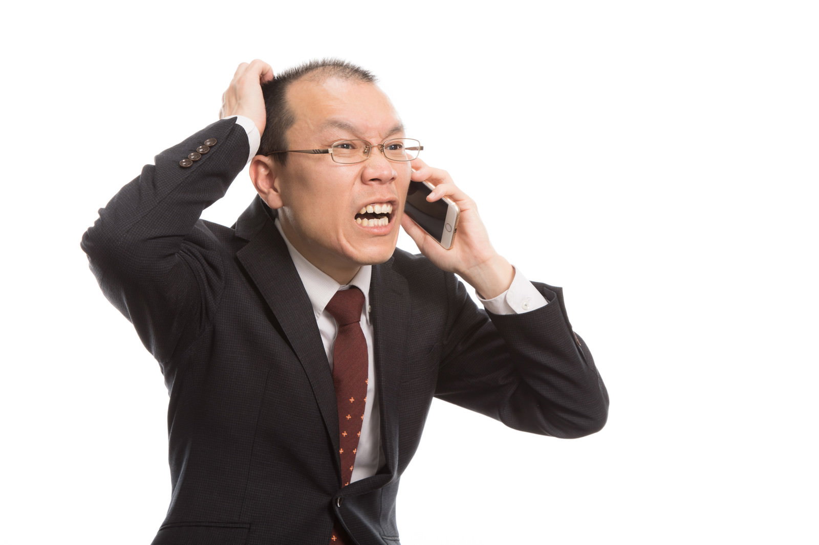 頭に手を当てながらスマートフォンで謝罪の電話をする薄毛の上司［モデル：サンライズ鈴木］