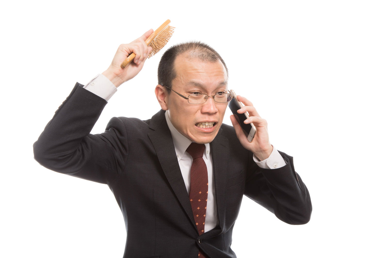 頭をかきながら困惑する若い男性［モデル：サンライズ鈴木］