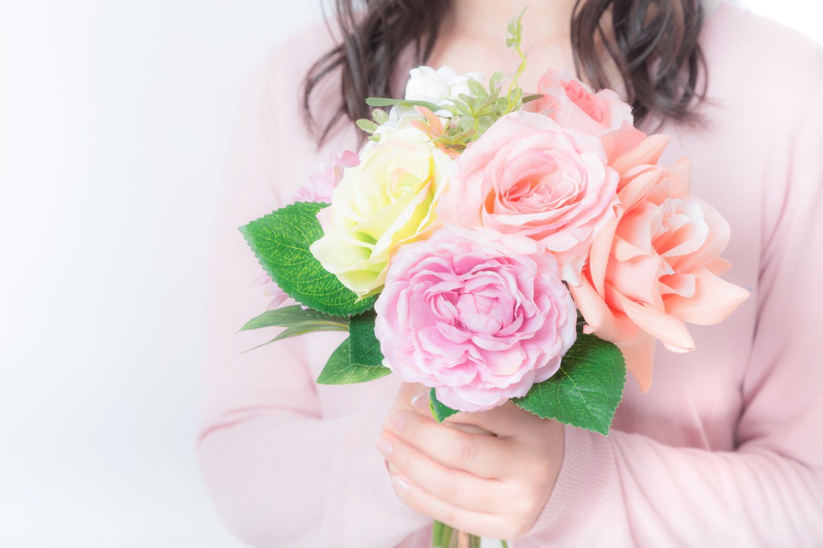 花束を両手で持つ女性