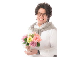 母の日に花をプレゼントする大手広告代理店勤務の男性の写真