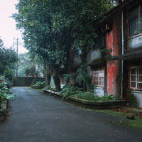 緑に覆われた廃村の物静かな路地 歴史的な赤レンガ建物と蔦に包まれた風景の写真