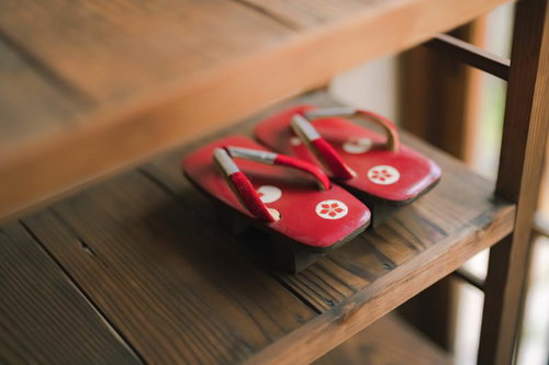 下駄箱に整然と入った女性用の赤い下駄と木製玄関収納