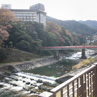 箱根湯本温泉を流れる川と紅葉した山々の秋景色の写真