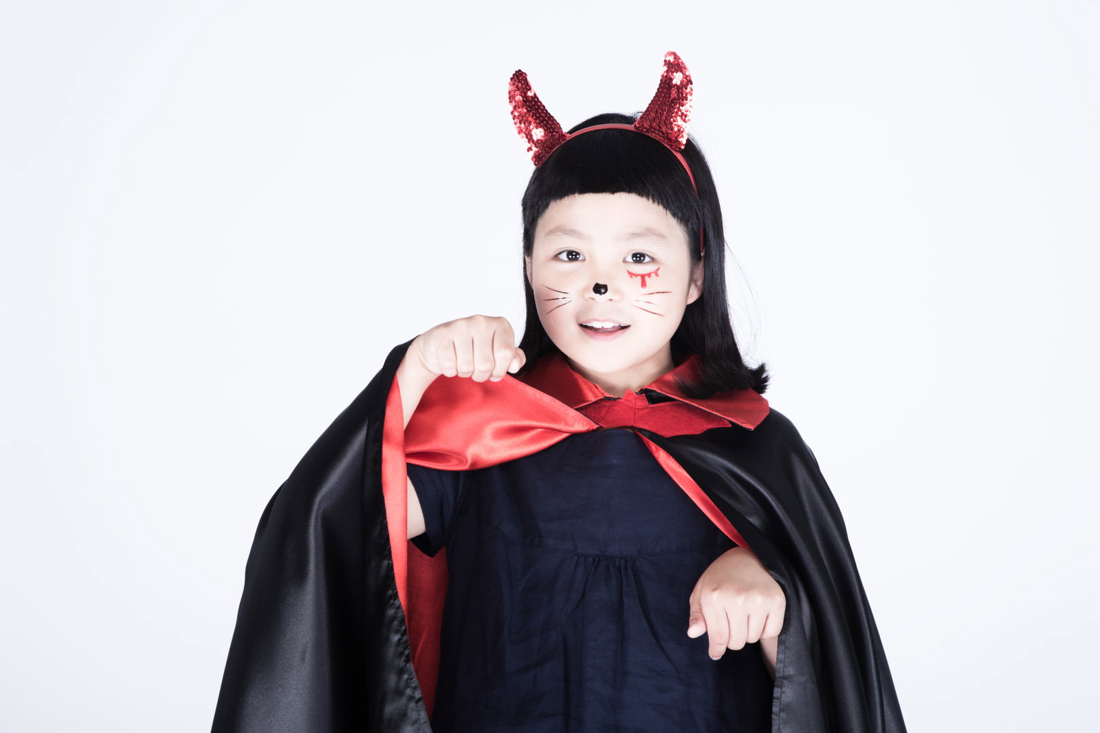 黒いマントと赤い角のカチューシャを身に着けた女の子がおねだりポーズ［モデル：ゆうき］