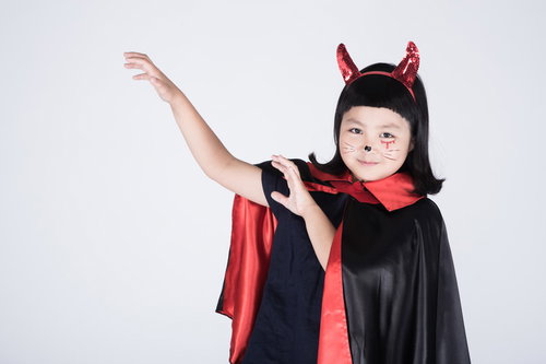 赤い角とマントのチビデビルが魔法を詠唱する仮装姿