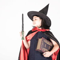 魔法書を持った魔女娘のハロウィン仮装コスプレの写真