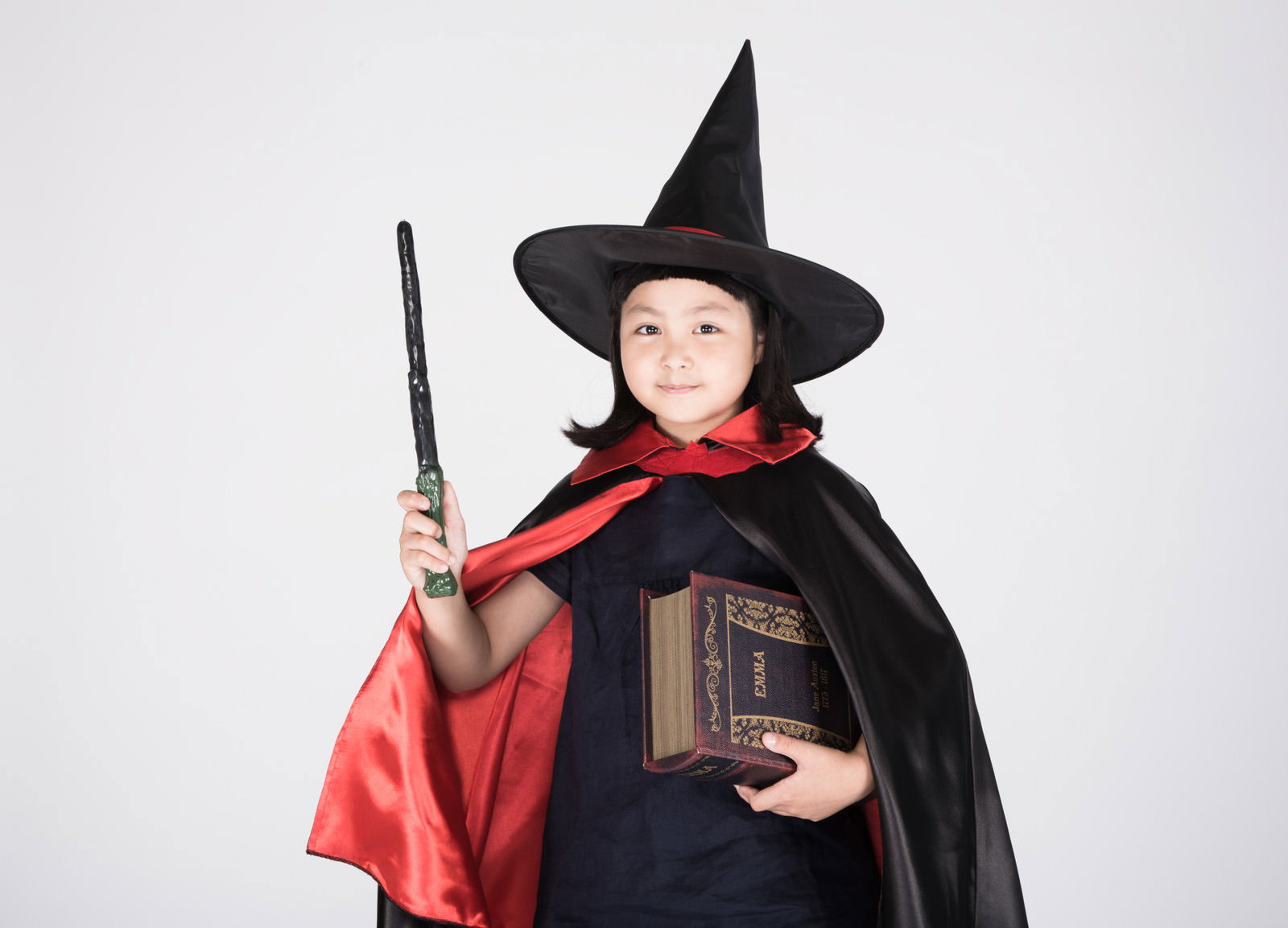 黒い三角帽子とマントを着てハロウィンの魔法使いに仮装した女の子［モデル：ゆうき］