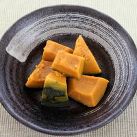 ハロウィーン風かぼちゃのおかず煮物、黒い器に盛り付けた和風の一品の写真