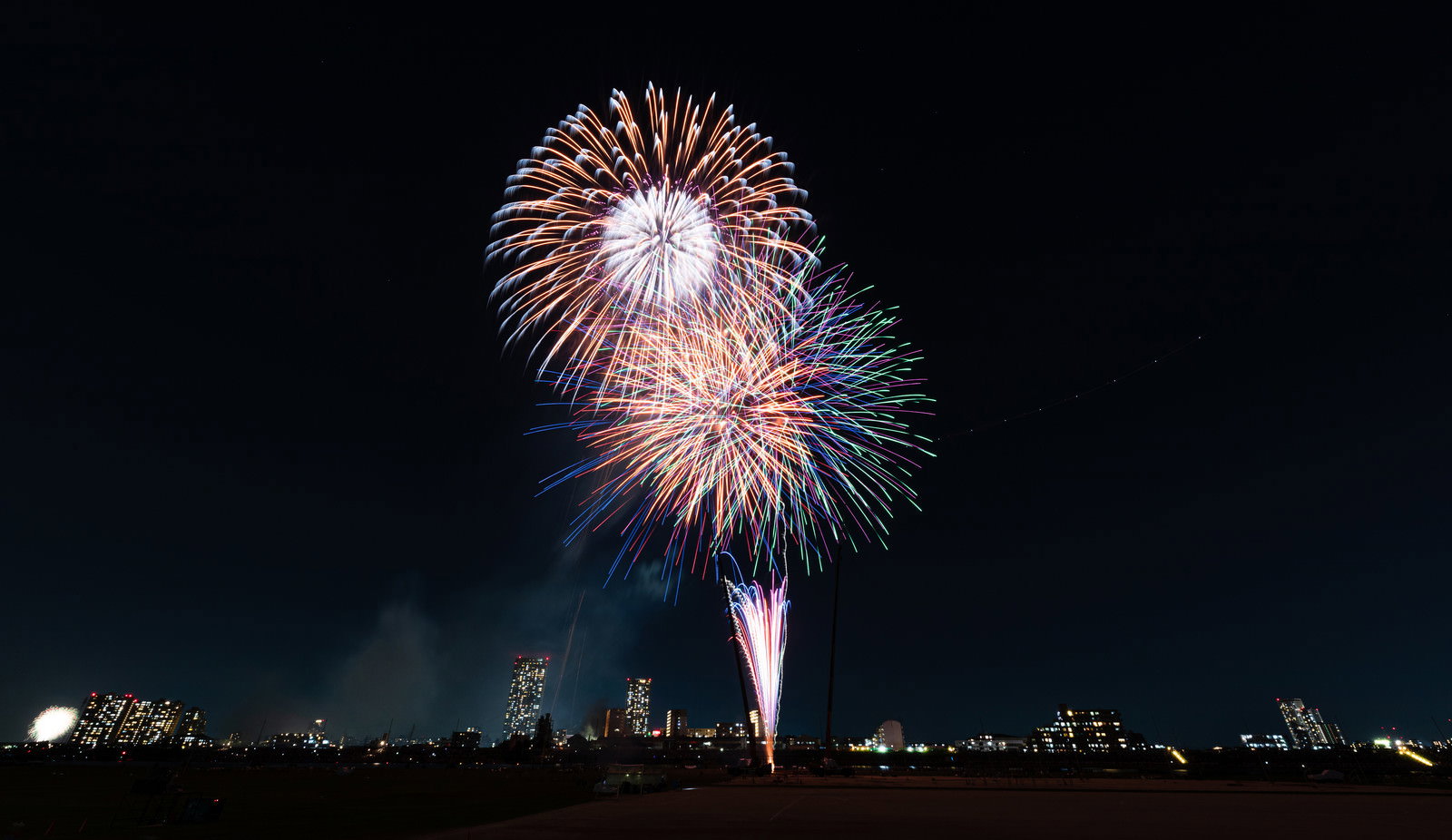 夜空に打ち上がる色とりどりの花火が光る様子