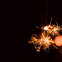 暗闇に弾けるせんこう花火の飛び散る明かりの写真