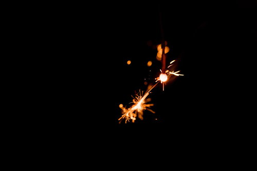 黒い背景に放射状に弾ける線香花火の火花と光跡