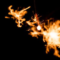 弾けた線香花火の火花が光る夜間の瞬間の写真